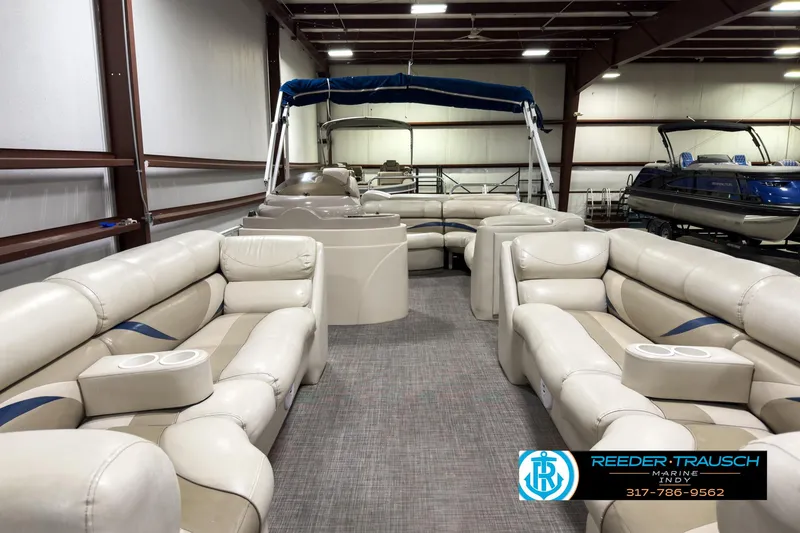 Slide: The Image of 2006 Crest Caribbean 2570 pontoon boat interior with beige seating in a showroom. - 13