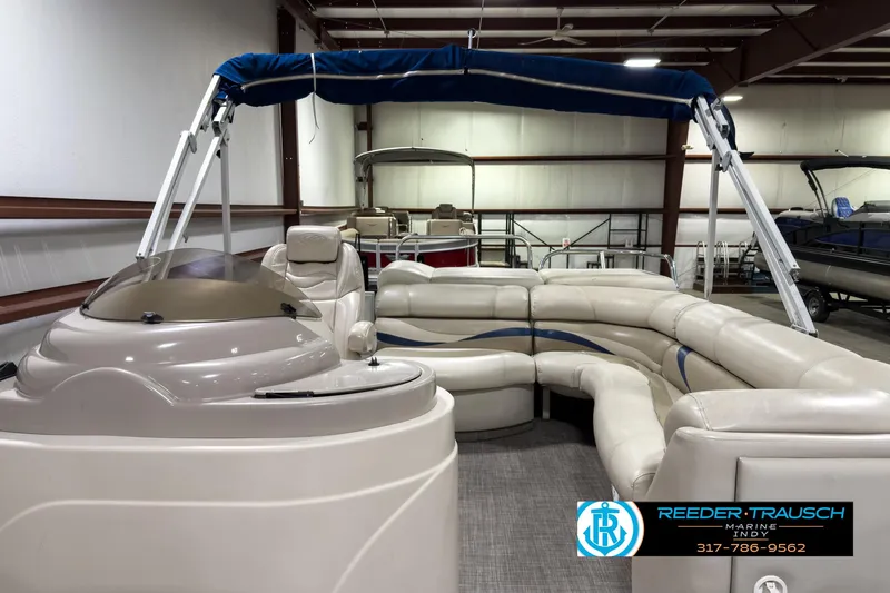 Slide: The Image of 2006 Crest Caribbean 2570 pontoon boat with beige seating and blue canopy in showroom. - 14