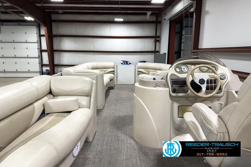 Slide: The Image of 2006 Crest Caribbean 2570 boat interior with beige seating and steering console in a garage. - 16