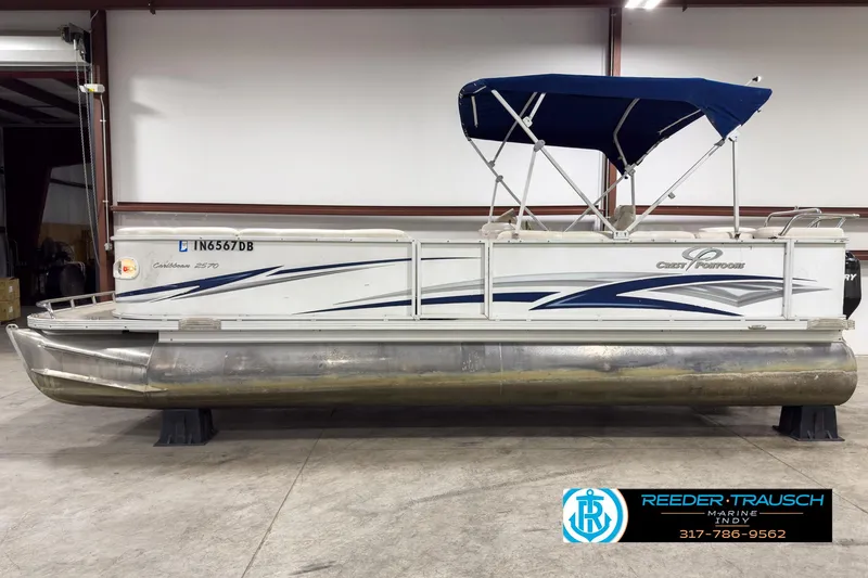 Slide: The Image of 2006 Crest Caribbean 2570 pontoon boat with blue canopy in indoor storage. - 5