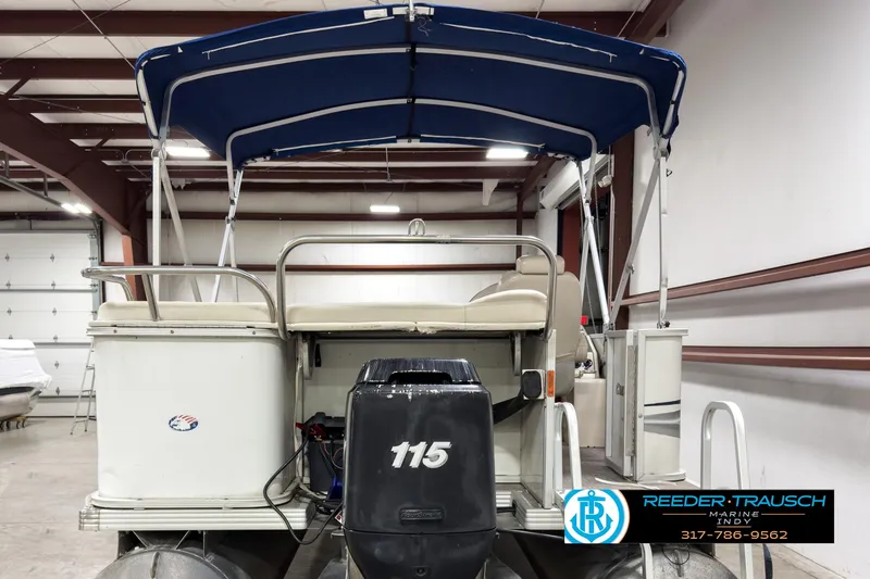 Slide: The Image of 2006 Crest Caribbean 2570 pontoon boat with blue canopy in indoor storage. - 7