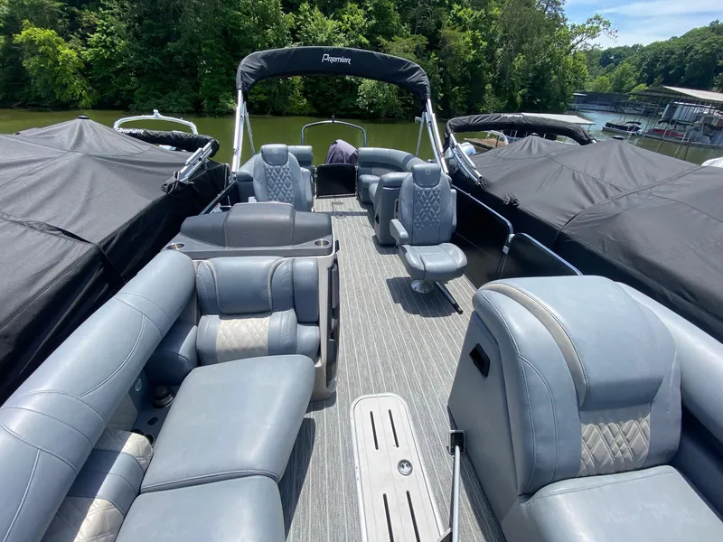 Slide: The Image of 2022 Premier 250 Grand Majestic RF pontoon boat with luxurious seating on a scenic lake. - 2