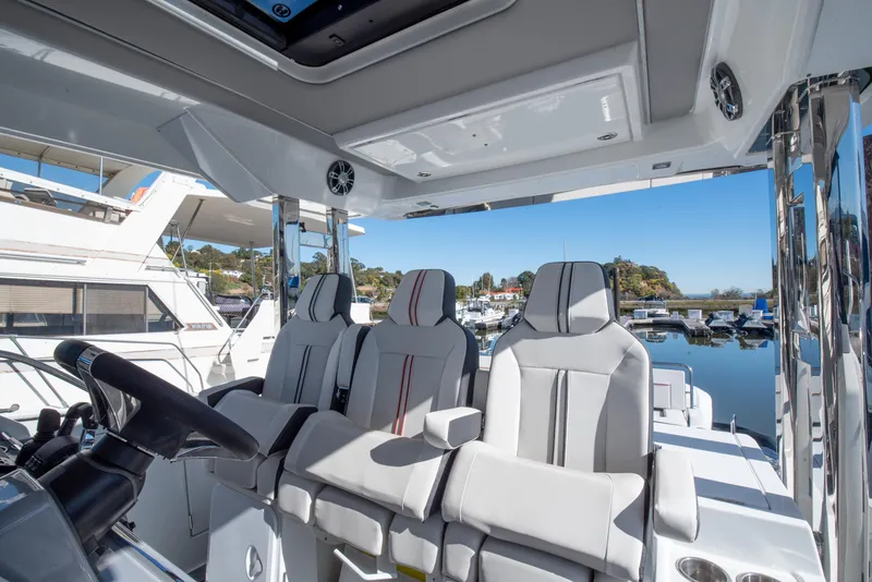 Slide: The Image of 2021 Jeanneau Leader 12.5 WA boat interior with modern seating and steering wheel. - 10
