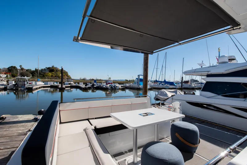 Slide: The Image of 2021 Jeanneau Leader 12.5 WA yacht docked at marina, featuring spacious seating and table. - 19
