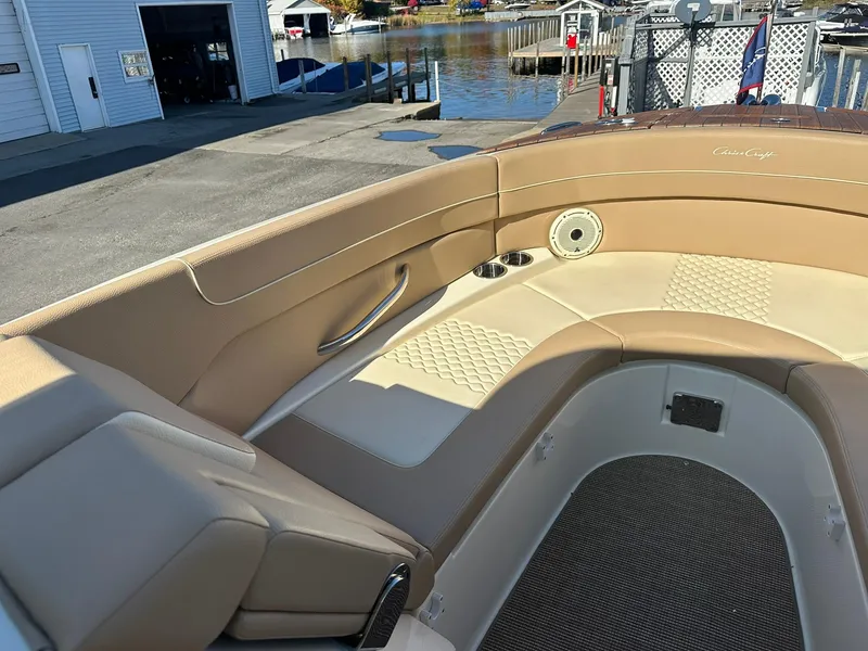 Slide: The Image of 2023 Chris-Craft Launch 28 GT boat interior with tan leather seating and dockside view. - 13