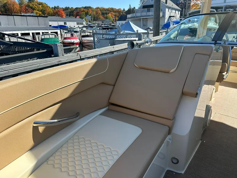 Slide: The Image of 2023 Chris-Craft Launch 28 GT boat interior with tan seating, docked at marina. - 16