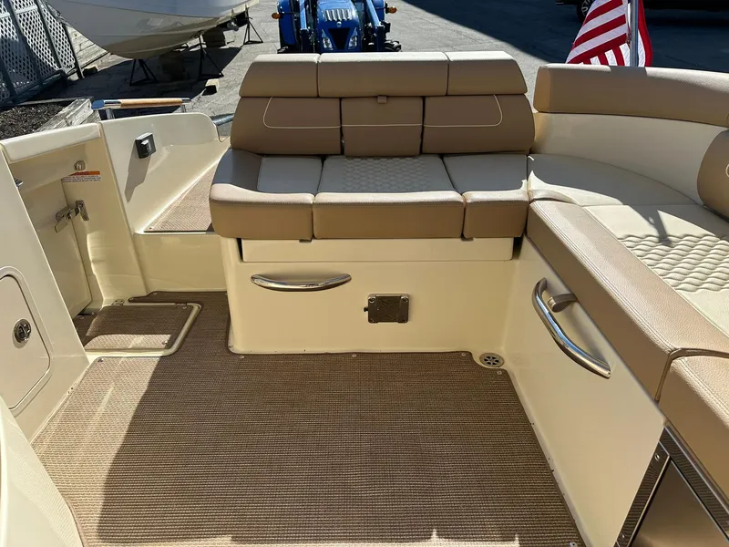 Slide: The Image of 2023 Chris-Craft Launch 28 GT interior with beige seating and American flag. - 19