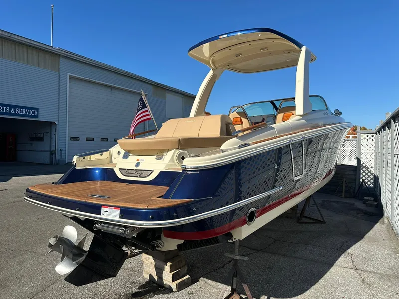 Slide: The Image of 2023 Chris-Craft Launch 28 GT boat with American flag, docked outdoors. - 4