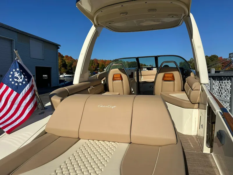 Slide: The Image of 2023 Chris-Craft Launch 28 GT boat with luxurious seating and American flag. - 7