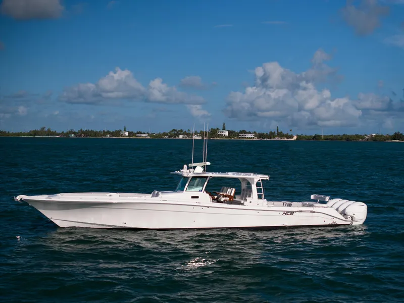 Slide: The Image of 2021 HCB 53 Sueños boat on calm blue water under a clear sky. - 0