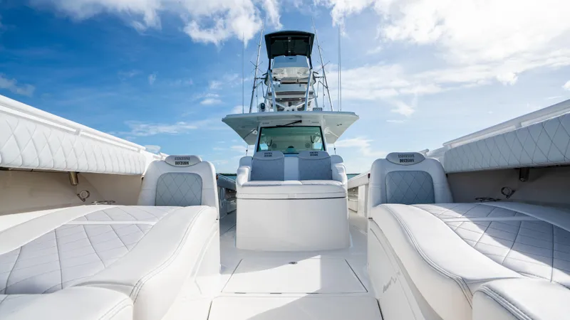 Slide: The Image of 2021 HCB 53 Sueños luxury boat interior with plush seating and clear blue sky. - 21