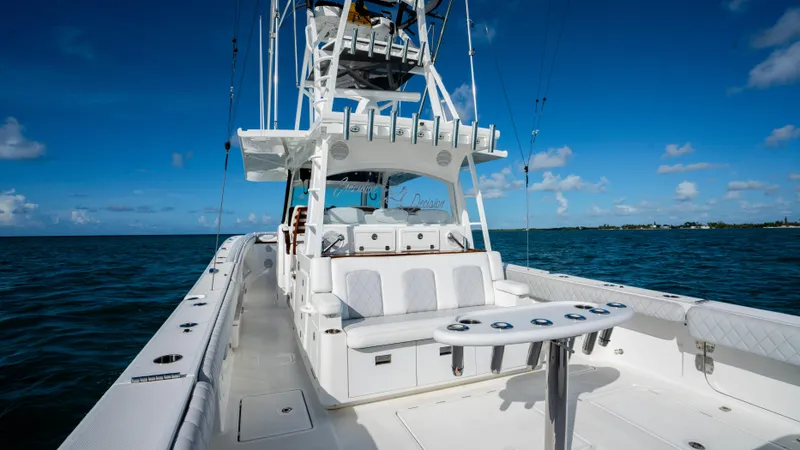 Slide: The Image of 2021 HCB 53 Sueños boat on open water, featuring spacious deck and seating. - 7