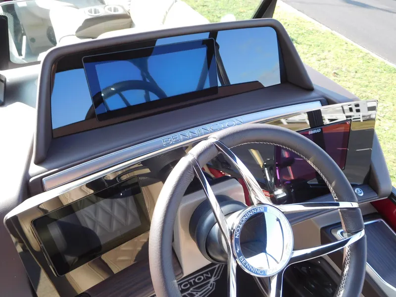 Slide: The Image of 2025 Bennington 25 QFB boat dashboard with modern steering and digital display. - 4