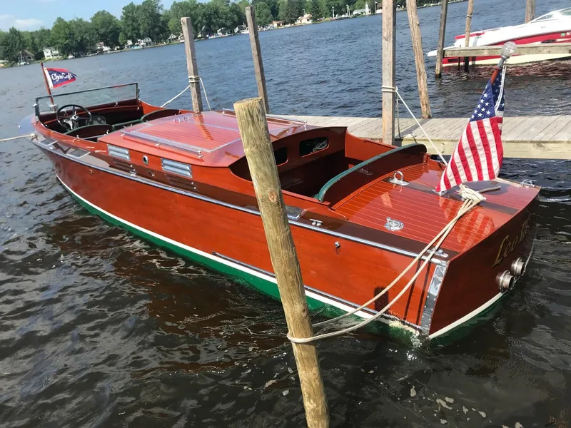 The Image of 1930 Chris-Craft Triple wooden boat docked on a lake. - 0