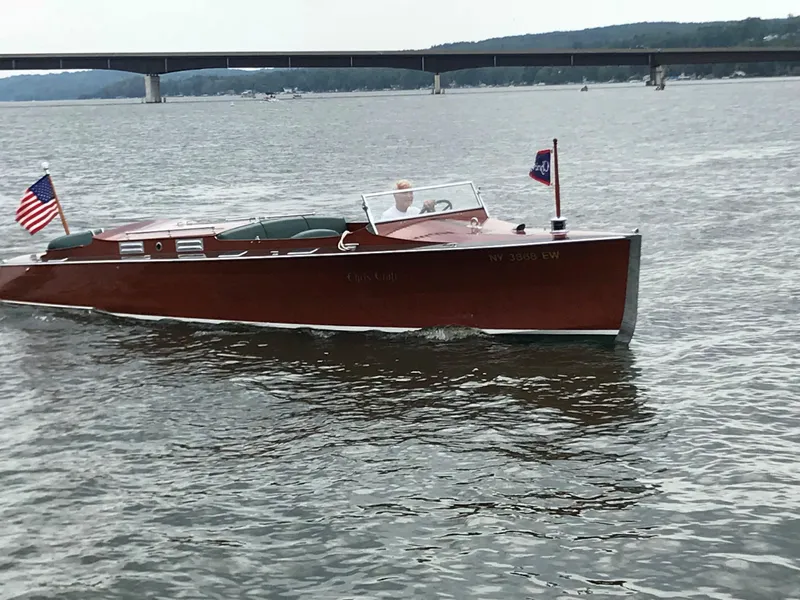 Slide: The Image of 1930 Chris-Craft Triple motorboat cruising on a lake with bridge in the background. - 15