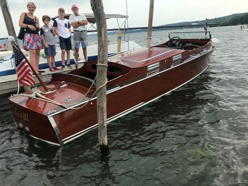 Slide: The Image of 1930 Chris-Craft Triple motorboat docked with people standing nearby. - 4