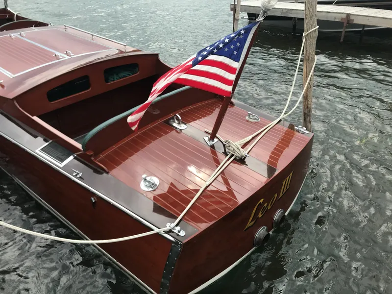 Slide: The Image of 1930 Chris-Craft Triple boat with American flag docked on water. - 5