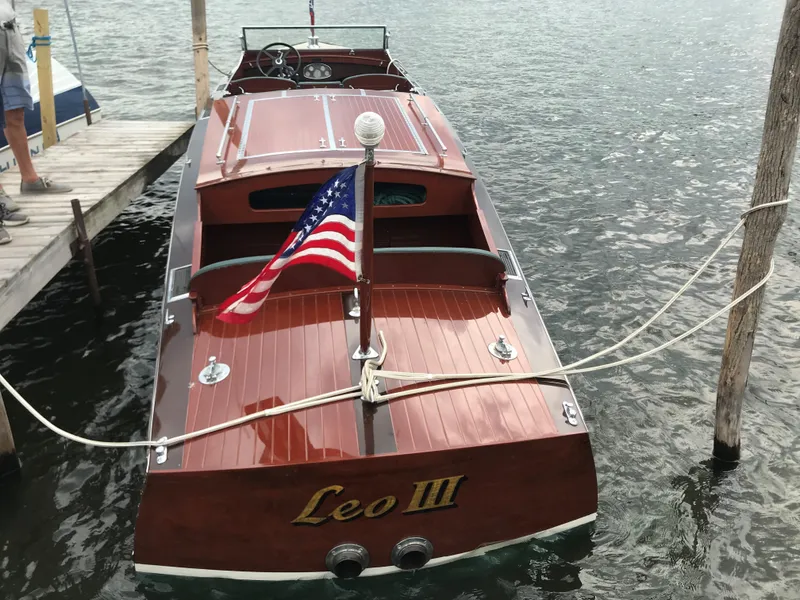 Slide: The Image of 1930 Chris-Craft Triple boat Leo III docked with American flag. - 6