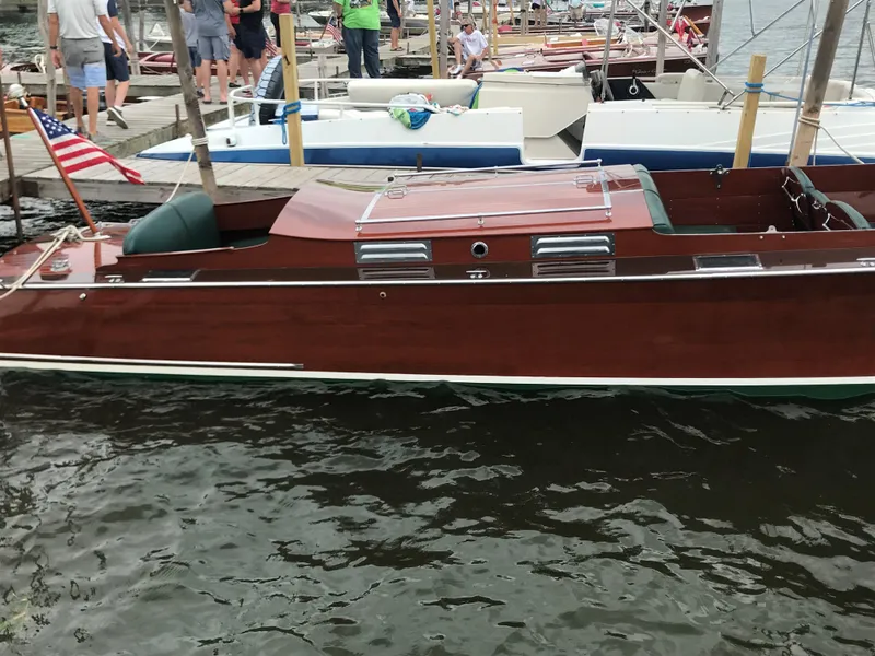 Slide: The Image of 1930 Chris-Craft Triple wooden boat docked at marina with people in background. - 7