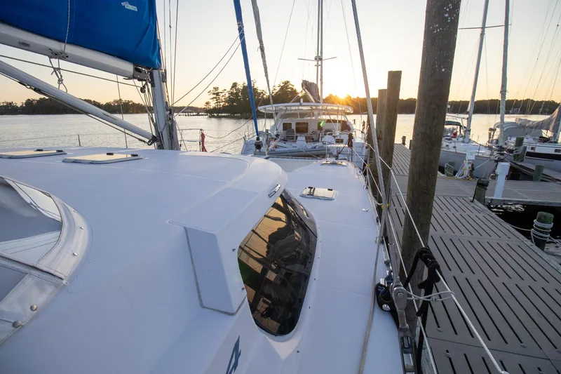 Slide: The Image of 2004 Antares PDQ 44 yacht docked at sunset, with scenic waterfront view. - 1