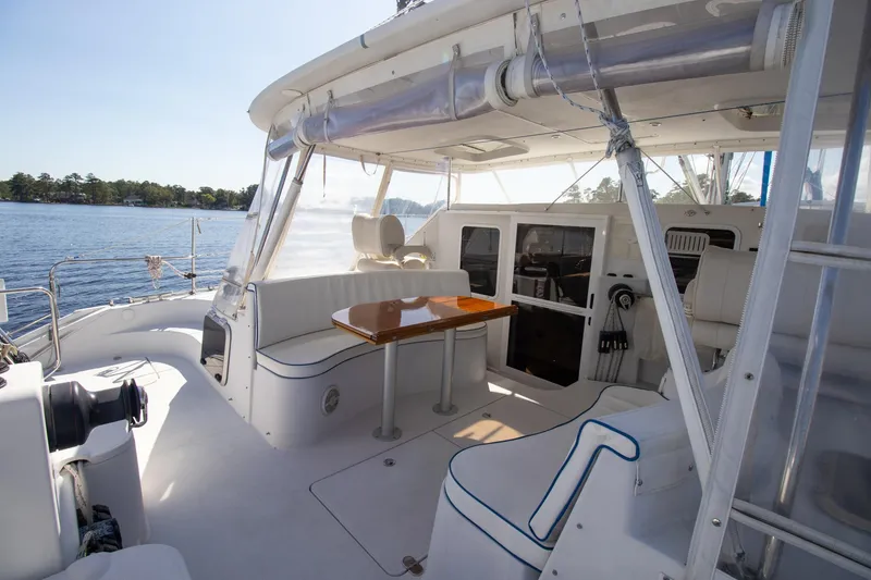 Slide: The Image of 2004 Antares PDQ 44 yacht deck with seating and table, overlooking serene water. - 14
