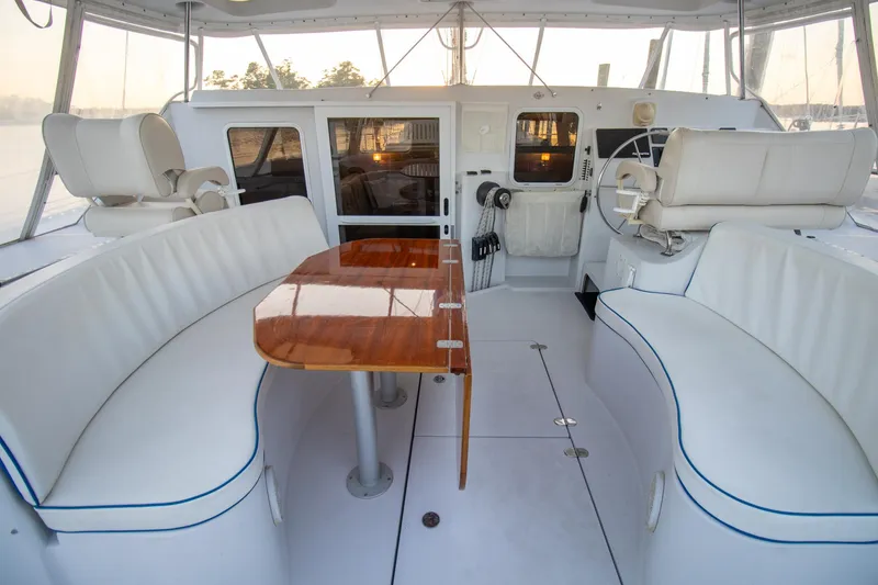 Slide: The Image of Luxurious 2004 Antares PDQ 44 yacht interior with white seating and polished wood table. - 18