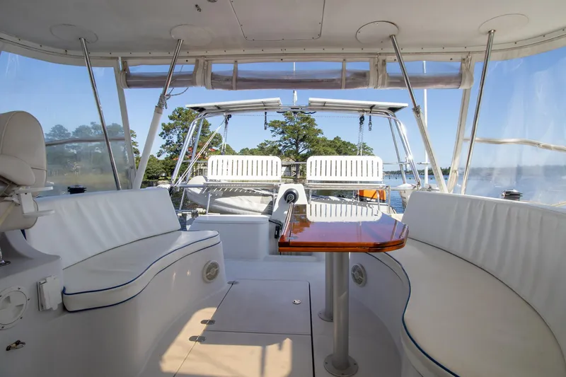 Slide: The Image of Luxurious 2004 Antares PDQ 44 yacht interior with white seating and polished wood table. - 19