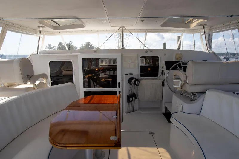 Slide: The Image of Interior view of 2004 Antares PDQ 44 yacht with white seating and wooden table. - 20