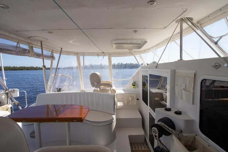 Slide: The Image of Spacious interior of 2004 Antares PDQ 44 yacht with seating and helm, overlooking serene waters. - 21