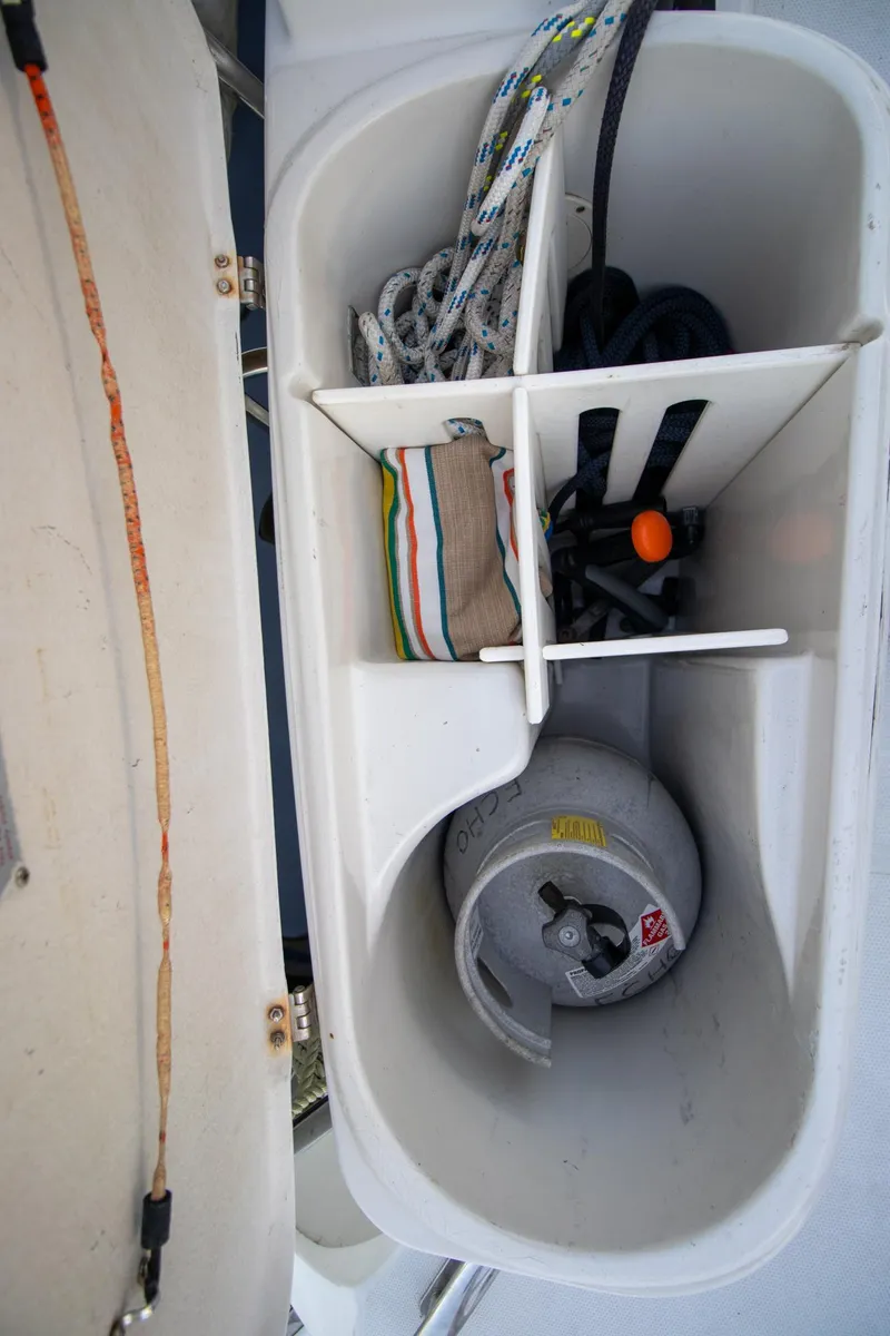 Slide: The Image of Storage compartment on 2004 Antares PDQ 44 boat with ropes and propane tank. - 23