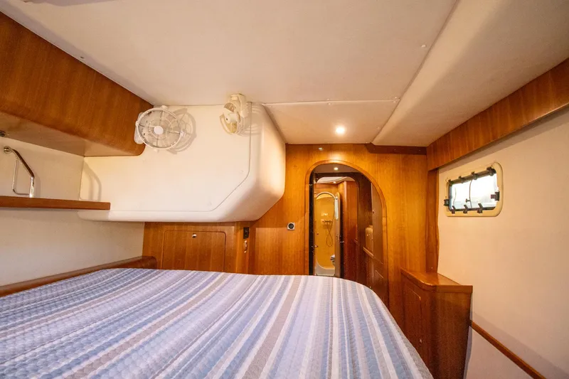 Slide: The Image of Cozy cabin interior of 2004 Antares PDQ 44 with wood paneling and striped bedding. - 37