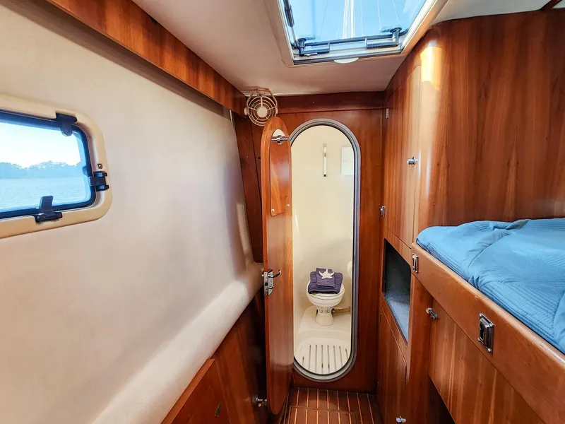 Slide: The Image of Interior of 2004 Antares PDQ 44 yacht cabin with wooden finish and compact bathroom. - 44