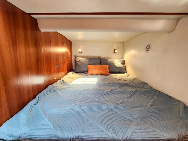 Slide: The Image of Cozy cabin bedroom in 2004 Antares PDQ 44 yacht with wood paneling and blue bedding. - 47