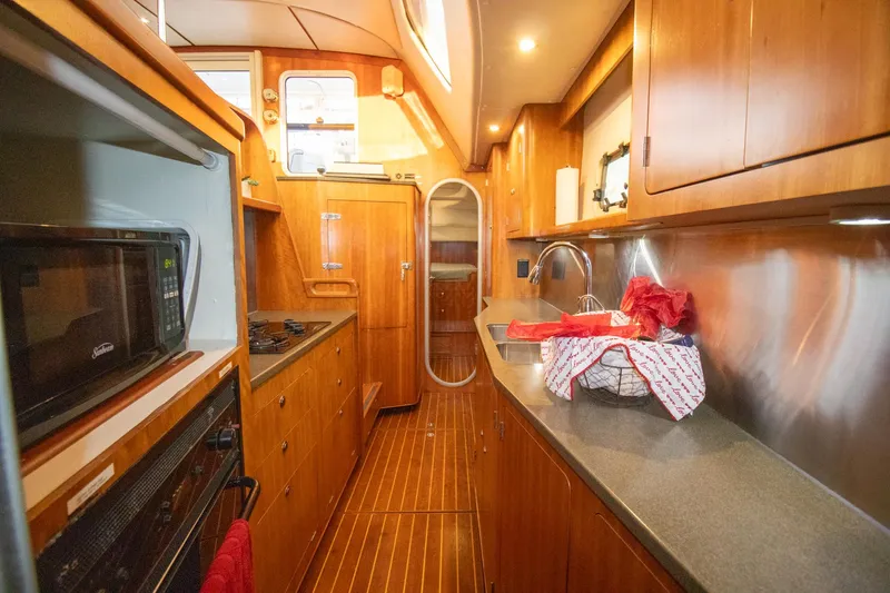 Slide: The Image of Luxurious 2004 Antares PDQ 44 yacht kitchen with wood cabinetry and modern appliances. - 49