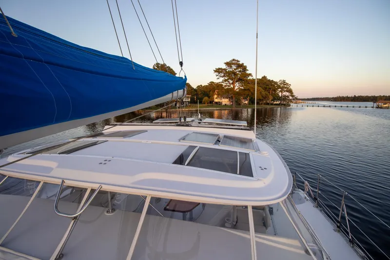 Slide: The Image of Sailing on Antares PDQ 44 catamaran, 2004 model, with scenic waterfront view. - 9