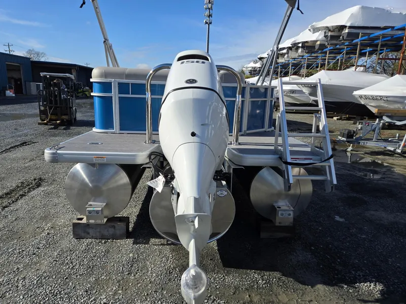 Slide: The Image of 2025 Godfrey Xperience Cruise 2086 CX pontoon boat with outboard motor, docked on gravel. - 4