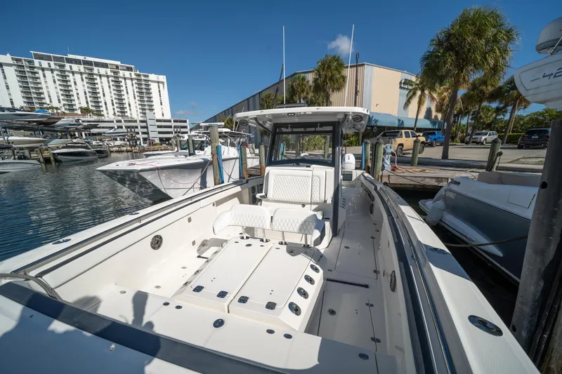 Slide: The Image of 2022 World Cat 400 CC-X boat docked at marina with modern buildings and palm trees. - 10