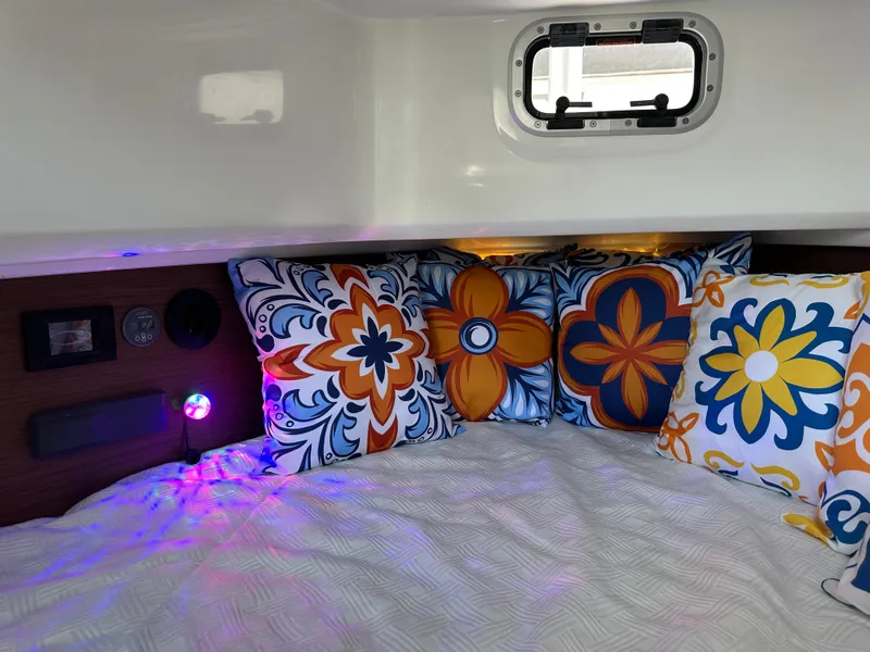 Slide: The Image of 2023 Jeanneau Leader 9.0 CC cabin with colorful floral pillows and cozy bedding. - 16