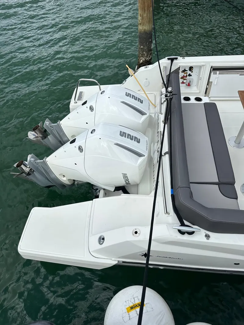 Slide: The Image of 2023 Jeanneau Leader 9.0 CC boat with dual outboard engines docked on water. - 30