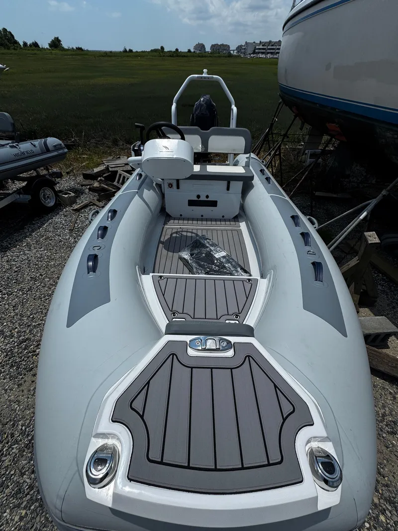 Slide: The Image of 2025 Highfield Classic 400 inflatable boat on gravel, featuring sleek design and modern seating. - 9