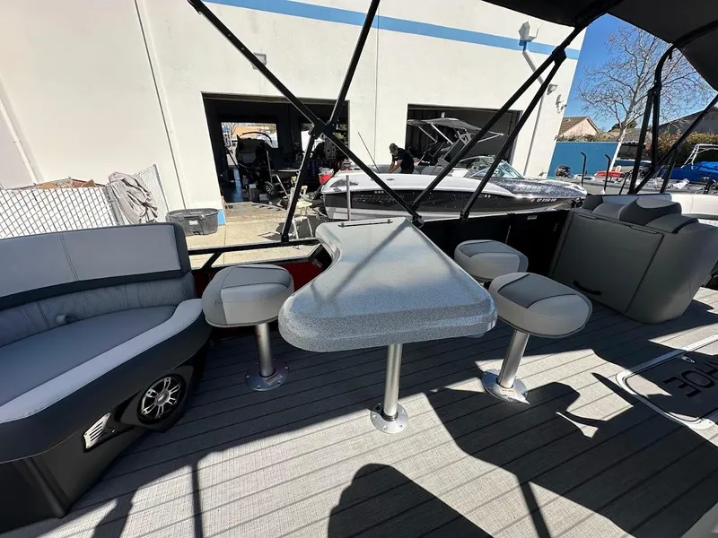Slide: The Image of 2025 Tahoe Pontoon 2585 LTZ Entertainer with seating and table on deck. - 13