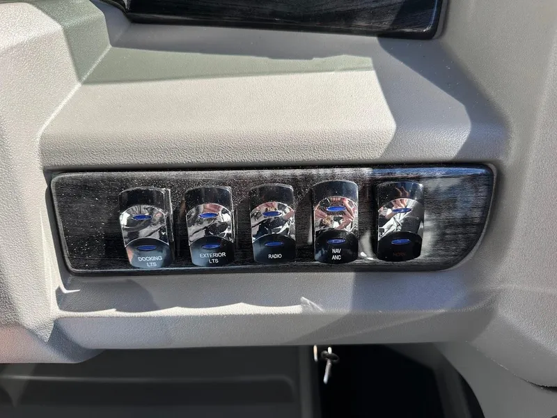 Slide: The Image of Control panel of 2025 Tahoe Pontoon 2585 LTZ Entertainer with labeled switches. - 26