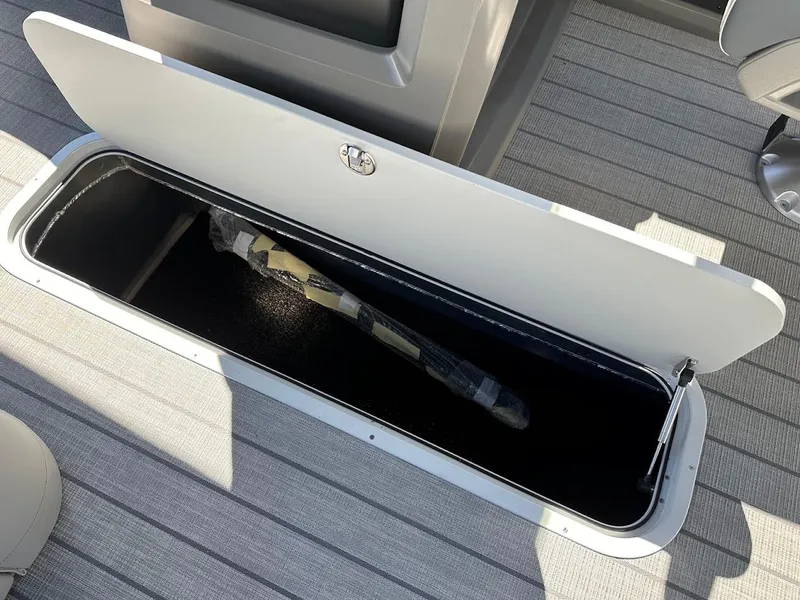 Slide: The Image of Storage compartment on 2025 Tahoe Pontoon 2585 LTZ Entertainer boat, open with item inside. - 29