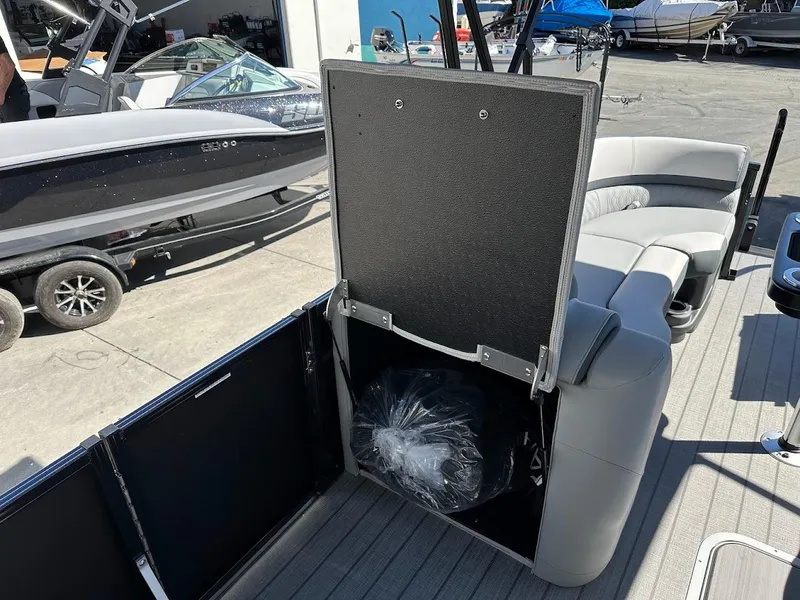 Slide: The Image of 2025 Tahoe Pontoon 2585 LTZ Entertainer interior with storage compartment open. - 30