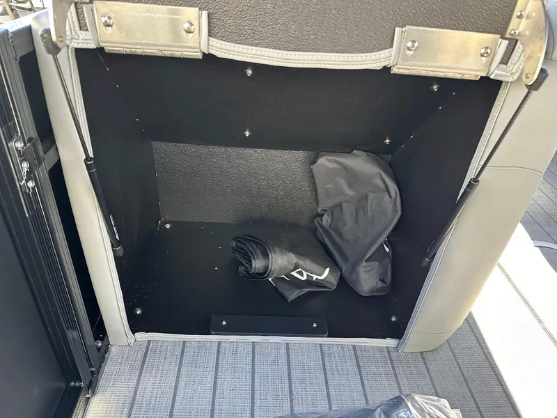 Slide: The Image of Storage compartment in 2025 Tahoe Pontoon 2585 LTZ Entertainer with folded cover inside. - 31