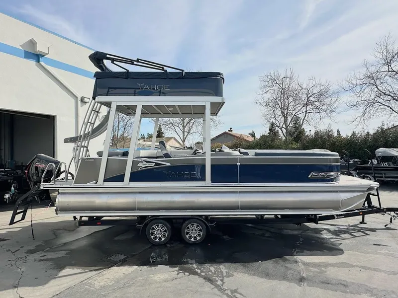 The Image of 2025 Tahoe Pontoon Cascade Cruise Funship, blue and silver, parked on a trailer outdoors. - 0