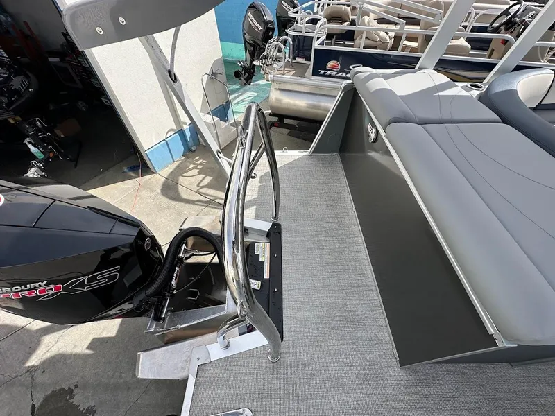 Slide: The Image of 2025 Tahoe Pontoon Cascade Cruise Funship with seating and outboard motor, docked in a marina. - 16