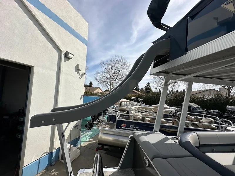 Slide: The Image of 2025 Tahoe Pontoon Cascade Cruise Funship with slide, parked near a building. - 17