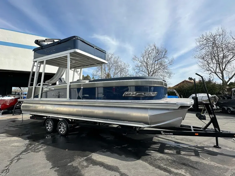 Slide: The Image of 2025 Tahoe Pontoon Cascade Cruise Funship on trailer, parked outdoors under clear sky. - 2