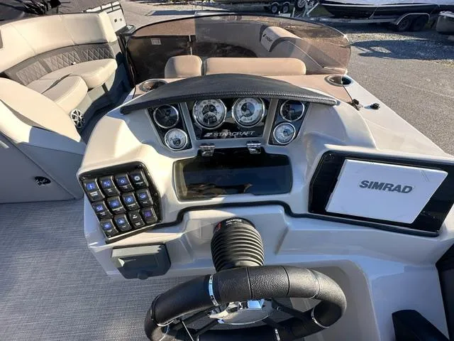 Slide: The Image of 2025 Starcraft SLS 1 boat dashboard with steering wheel and Simrad display. - 4